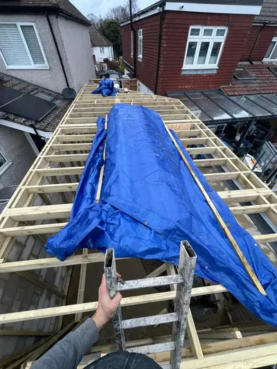 New timber roof joists on an extension, partly sheeted with tarpaulin