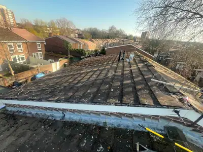 Cleared roof slope with the edge and verge repaired after moss removal, in low winter sun